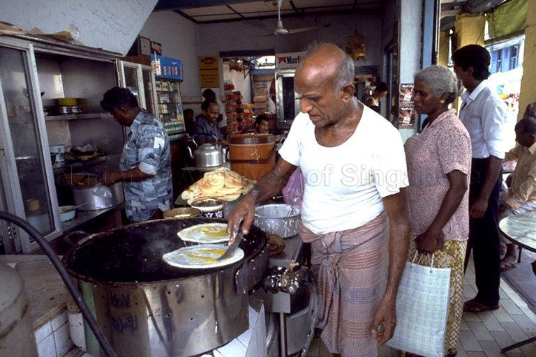 Man making roti prata in coffee shop in Serangoon Road area