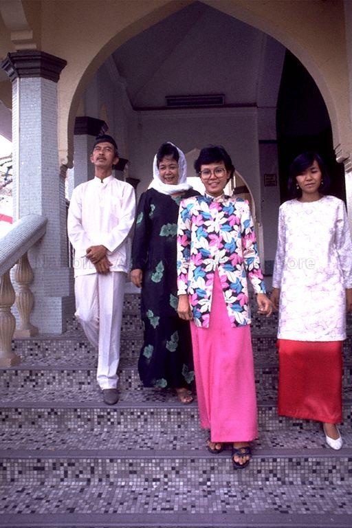Ladies and a gentleman leaving Sultan Mosque in Kampong Glam