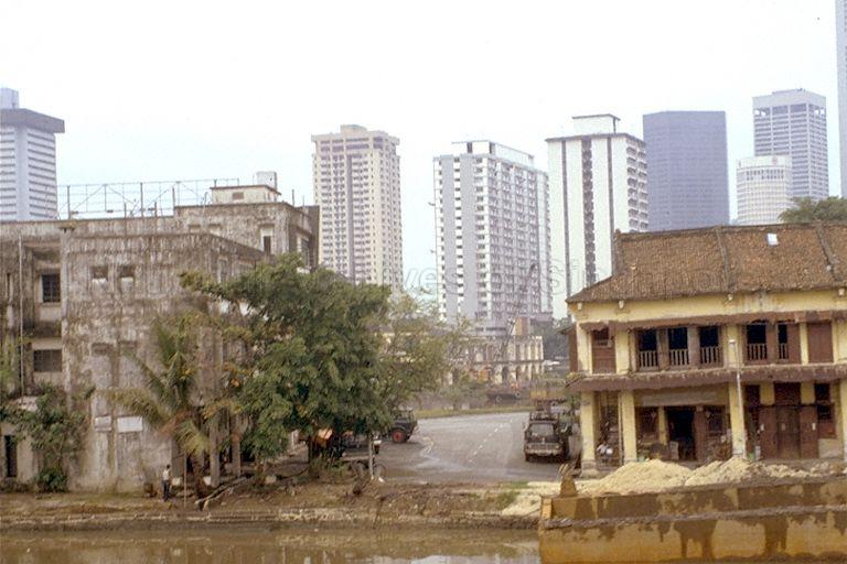 Godowns at Singapore River, with high-rise flats and office buildings in the background. High Street Centre is on the far left, while on the right are some of the skyscrapers at Raffles Place, such as UOB Building, Standard Chartered Bank and part of OUB Centre.