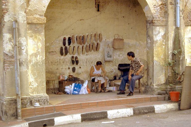 Cobbler at work along the five-foot way of a shophouse along St Gregory's Place