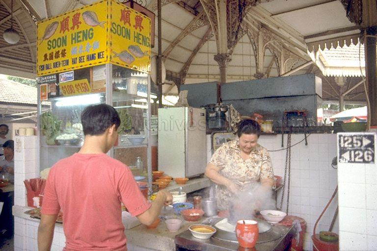 Customer ordering fishball noodles from a stall at Lau Pa Sat
