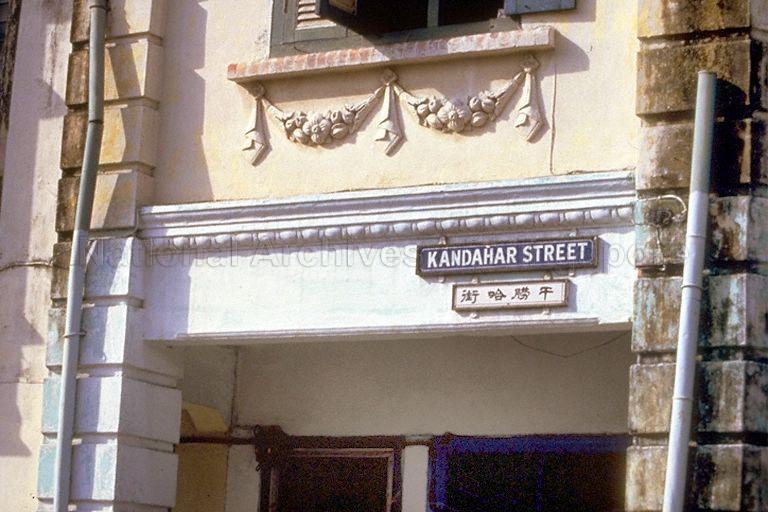 Old Kandahar Street sign on the side of a shophouse in English and Chinese.