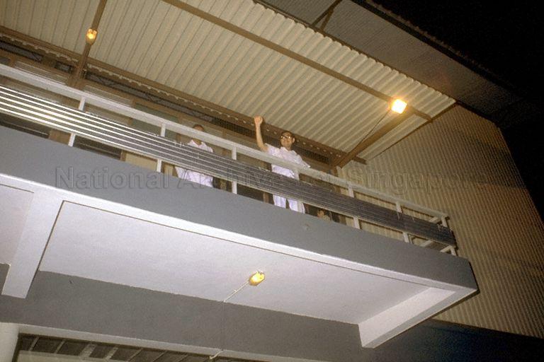 A People's Action Party (PAP) candidate emerges on balcony of the counting centre waving to party supporters during the Singapore General Election.