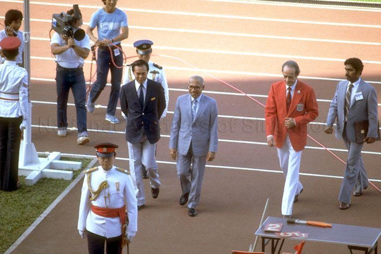 Singapore President Devan Nair (in grey suit) leaving the field after having met the players and referees before the Southeast Asian Games (SEA Games) 1983 football final between Singapore and Thailand at Singapore's National Stadium. He is accompanied by SEA Games Federation President and Minister for Law and Labour E W Barker (in red jacket). Thailand eventually won the match 2-1.