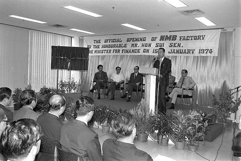 An official speaking at the opening ceremony of NMB Singapore Pte Ltd at Chai Chee Avenue. Minister for Finance Hon Sui Sen is also on the stage, seated third from left.