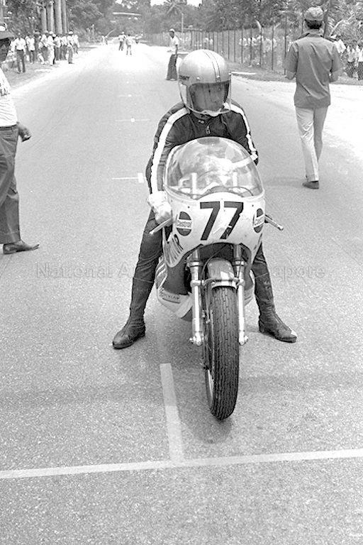 A motorcyclist preparing to ride his motorcycle before the start of the race during the Singapore Grand Prix 1971 at Sembawang Hills Circuit.