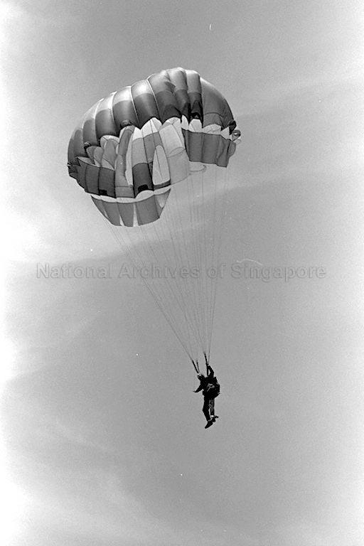 A sky-diving performance by members of Joint Services Sports Parachute Association at the Singapore Grand Prix 1971 at Sembawang Hills Circuit.