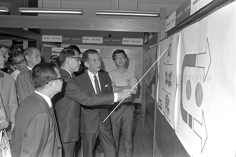 President Dr Benjamin Henry Sheares, who is also Chancellor of University of Singapore, being briefed by Director of Development Unit of University of Singapore Ho Pak Toe on the phases of work to be carried out for Kent Ridge campus during a visit to the University of Singapore campus at Bukit Timah. Also present is Minister for Science and Technology and Vice Chancellor Dr Toh Chin Chye (foreground, side facing camera).