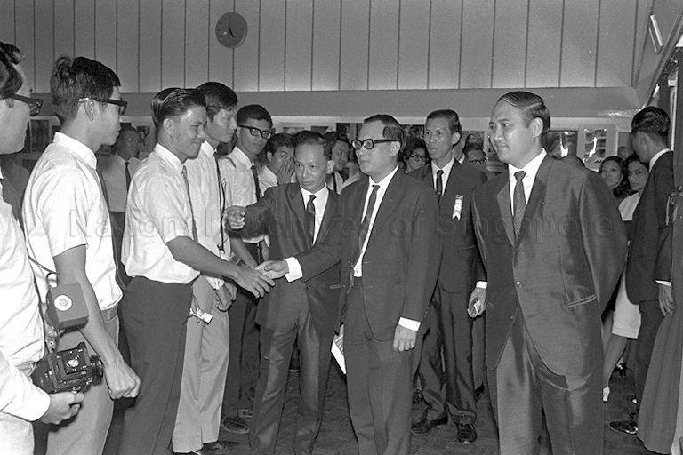 Minister for Home Affairs Dr Wong Lin Ken (centre) is greeted upon arrival for the opening of the three-day Adult Education Board's Photographic Exhibition at the National Library. Also present is Minister of State for Education Dr Lee Chiaw Meng (far right).
