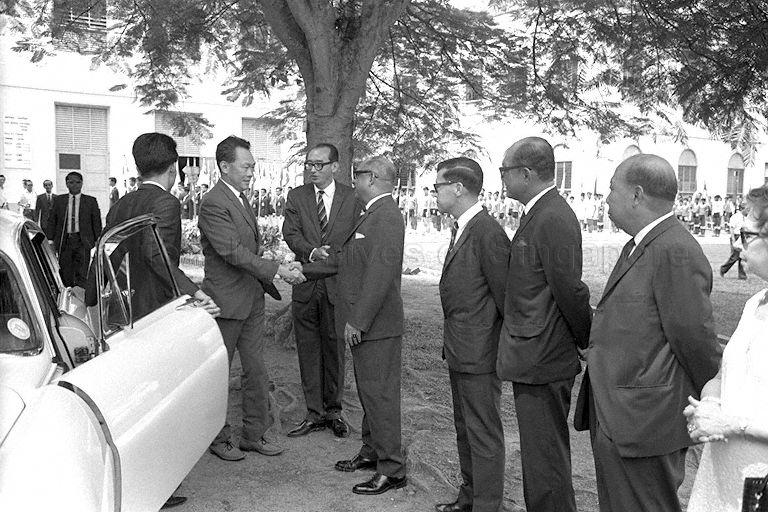 Prime Minister Lee Kuan Yew being introduced to Dr A C Sinha, a member of Raffles Institution (RI)'s Advisory Committee, by Principal Philip Liau upon arrival at RI in Bras Basah Road to attend 146th Founder's Day celebration