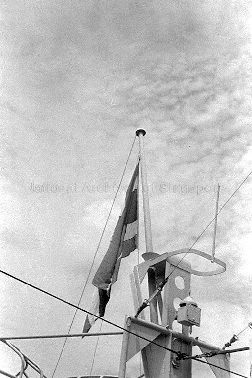 Siamese flag being raised during handover ceremony of minesweeper HMS Minstrel from British Royal Navy to Royal Siamese Navy, held at Naval Dockyard, Singapore