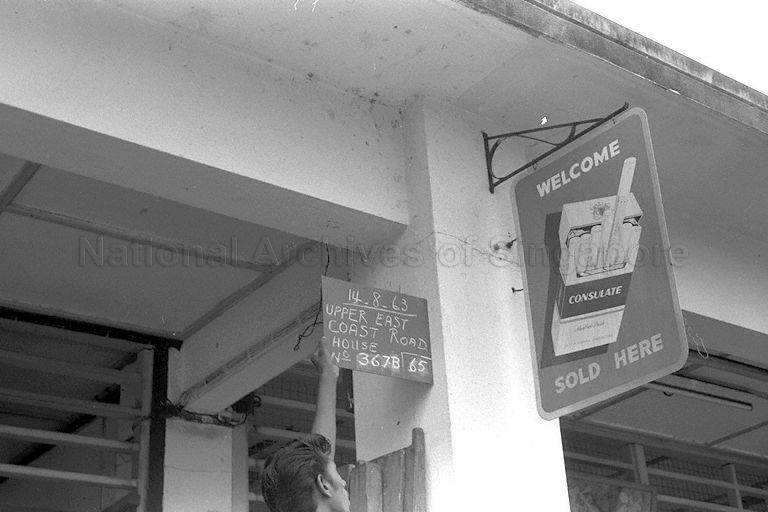 A "Consulate" brand cigarette signboard hanging on the external pillar outside house No. 367B Upper East Coast Road