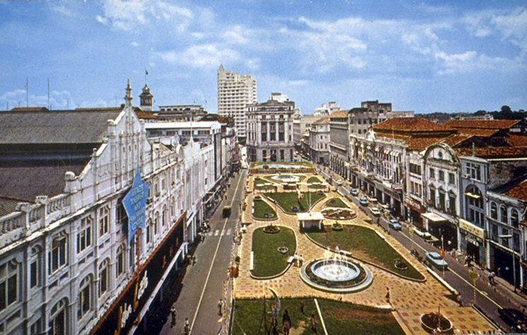 View of Raffles Place, Singapore, with John Little (left), Mercantile Bank building (centre, far end) and the rooftop public garden of the underground car park, featuring two water fountains and a flower clock