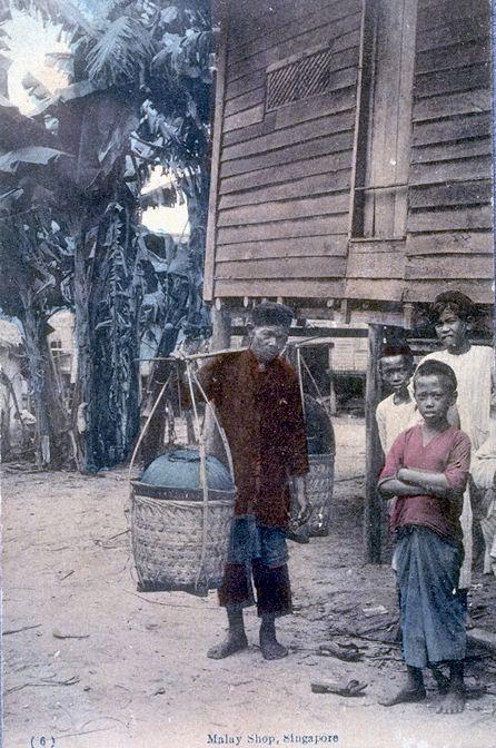 Malay "kueh" or cakes hawker carrying his wares and Malay boys in a "kampong" or village, Singapore