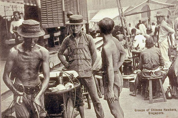 Chinese street hawkers plying their trade outside Telok Ayer Market or Lau Pa Sat, Singapore. Hawkers who operated food carts and stalls, like those in the image, were a familiar sight in Singapore until they were moved to more sanitary modern hawker centres starting from the 1950s.