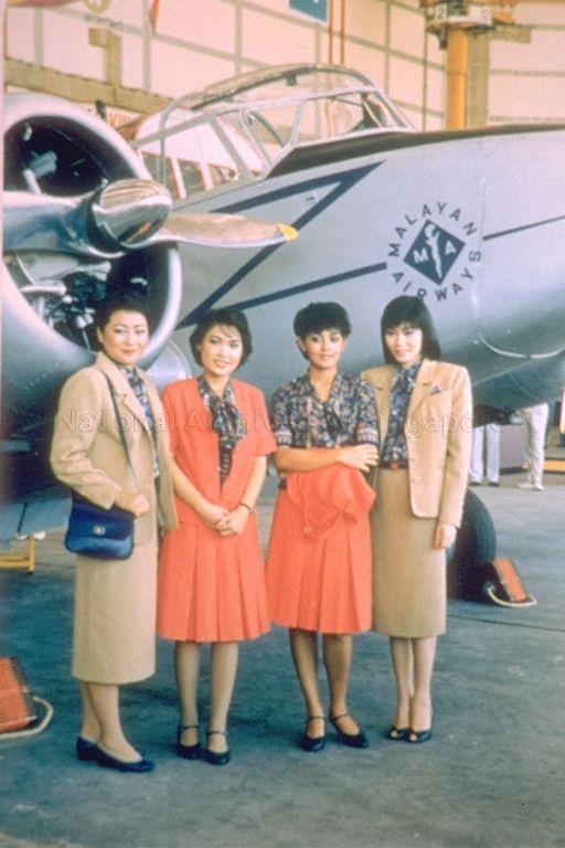 New and old uniforms for ground stewardesses and female ticketing staff. The old uniform created by French designer Pierre Balmain in 1974 comprised of a blue batik blouse, tomato-red jacket, matching pleated skirt, and shoes with straps. This was replaced by the new beige jacket and skirt suit.