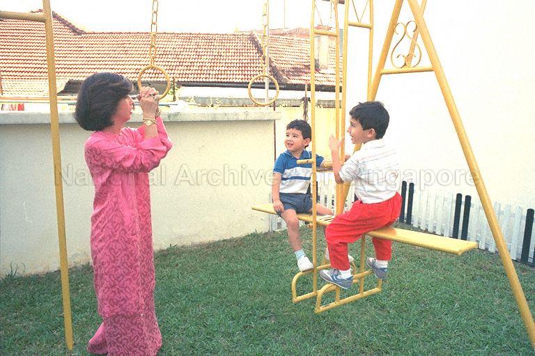 Malaysian princess Tunku Besar Zabedah, daughter of the Yang di-Pertuan Agong, Sultan Iskandar of Johor, looking after her two nephews - Tengku Sallehuddin Ismail Iskandar Ibrahim Hishamuddin Shah (red pants) and Tengku Shahrain (blue shorts), in the playground at Darul Ihsan Lilbanet orphanage at 23 Wan Tho Avenue, off Upper Serangoon Road.