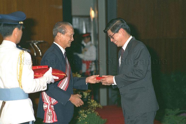 President Wee Kim Wee presenting Public Administration Medal (Gold) to Deputy Secretary of Ministry of Home Affairs and Director of Internal Security Department Tjong Yik Min for outstanding leadership at investiture ceremony for 1988 National Day awards held at Singapore Conference Hall