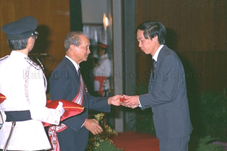 President Wee Kim Wee presenting medal to recipient at investiture ceremony for 1988 National Day awards at Singapore Conference Hall