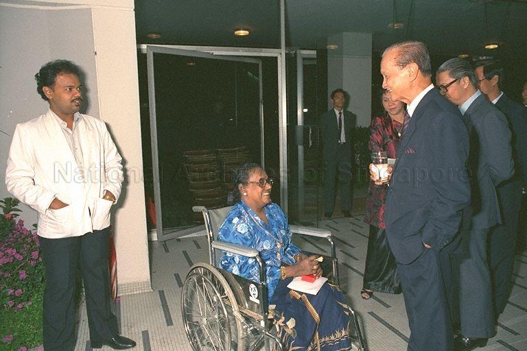 President Wee Kim Wee and Minister for Education Dr Tony Tan (second from right) talking with Madam Noorsinah binti Jan and her son Abdul Razak bin Mohd Zakaria (left) during reception after investiture of 1988 National Day awards for efficiency and long service held at Singapore Conference Hall. She had earlier received the long service medal from Dr Tan. The 55-year-old former health attendant with Middle Road Hospital had her right leg amputated due to her diabetic condition two months ago.