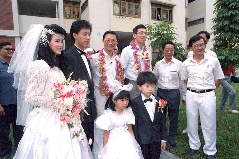 Group photograph of ministers with the wedding couple during their ministerial tour of Marine Parade Group Representation Constituency (GRC). From right (front) are, the GRC Member of Parliament Choo Wee Khiang, grassroot leader, Minister for Trade and Industry and Second Minister for Defence Brigadier-General Lee Hsien Loong, Senior Minister of State for National Development and Home Affairs Dr Lee Boon Yang, bridegroom and bride.