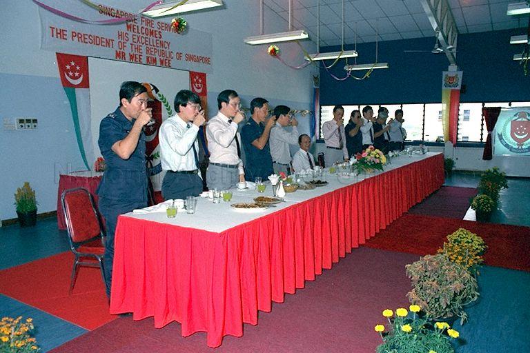 Officials of Ang Mo Kio Fire Station, (from left) Senior Minister of State for National Development and Home Affairs Dr Lee Boon Yang (seventh), and Singapore Fire Service Deputy Director (Operations and Training) Tan Jin Thong (eighth) proposing toast to President Wee Kim Wee during lunch at Ang Mo Kio Fire Station in Ang Mo Kio Avenue 9.