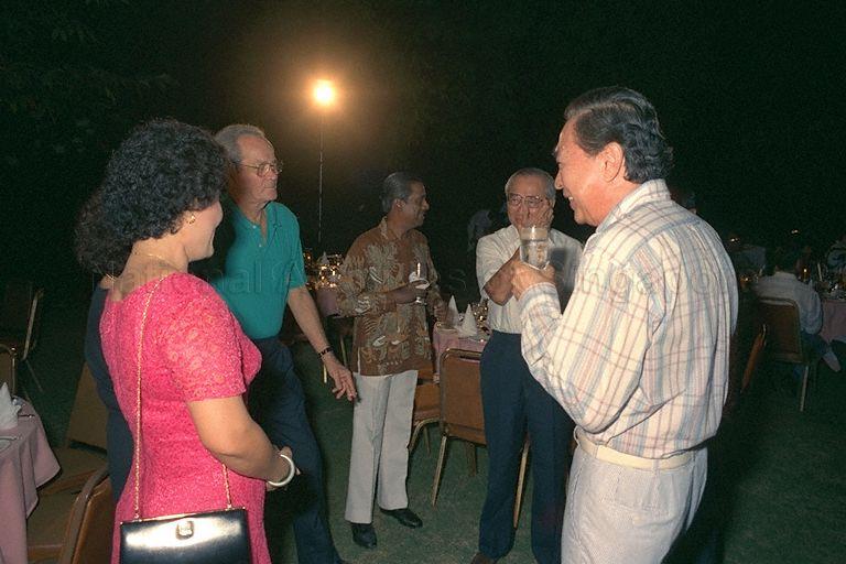 Retired People's Action Party (PAP) Members of Parliament (MP) E W Barker (third from left) and Dr Yeoh Ghim Seng (right) catching up with each other during the valedictory dinner in the garden between Parliament House and its Annexe. Mr Barker, Minister for Law, has been MP for Tanglin since 1963 when he was first elected. Mr Barker is now chairman of the Bukit Turf Club. Dr Yeoh, MP for Joo Chiat, has been the Speaker of Parliament for nearly 19 of the 23 years that Singapore has been independent. He was elected in 1966. Dr Yeoh is now a surgeon in private practice. Also present are (from right) Minister for Finance Dr Richard Hu (second), and Minister for Law and Home Affairs Professor S Jayakumar (third).