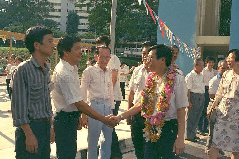 Minister of State for Communications and Information and Trade and Industry Mah Bow Tan (garlanded) greeting grassroots leaders at Block 2, Queen's Road. He is accompanied by the constituency's Member of Parliament Dr Dixie Tan (right).