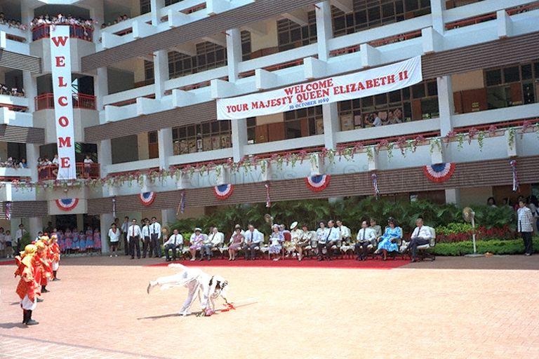 Students of Townsville Primary School performing a cultural dance for Her Majesty Queen Elizabeth II (seated in the background) during a visit to the school in Ang Mo Kio