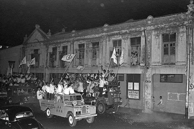 Celebratory convoy consisting of Prime Minister Lee Kuan Yew, Minister of Finance Goh Keng Swee and other People's Action Party (PAP) members on a Land Rover driving past Neil Road after the 21 September 1963 elections where PAP was re-elected to a second term after it won 37 out of the 51 seats in the Singapore Legislative Assembly Election of 1963