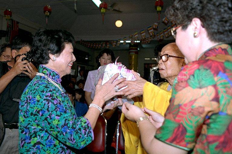 Venerable Seck Kong Hiap, founder of Mee Toh School and past president of Singapore Buddhist Federation, presenting a gift to First Lady Mrs Wee Kim Wee during the Vesak Day celebrations at the school at Race Course Road. With them is Principal Mrs Tan Chin Cheoh (back to camera).