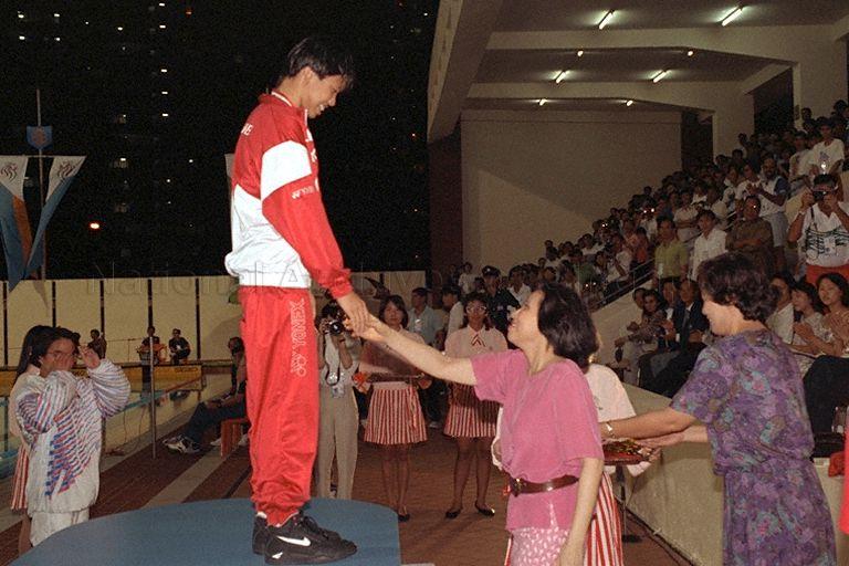 Singapore swimmer Joscelin Yeo receiving her gold medal for women's 200 metres freestyle at victory ceremony during 17th Southeast Asian (SEA) Games at Toa Payoh Swimming Complex