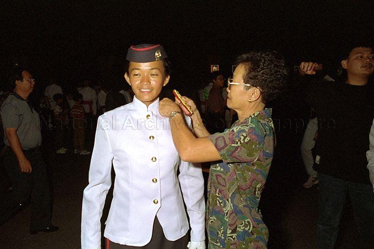 A newly-commissioned officer receiving an epaulette from a family member during the Tri-Service Commissioning Parade for officer cadets held at the Singapore Armed Forces Training Institute (SAFTI). &nbsp;The parade was reviewed by President Wee Kim Wee.