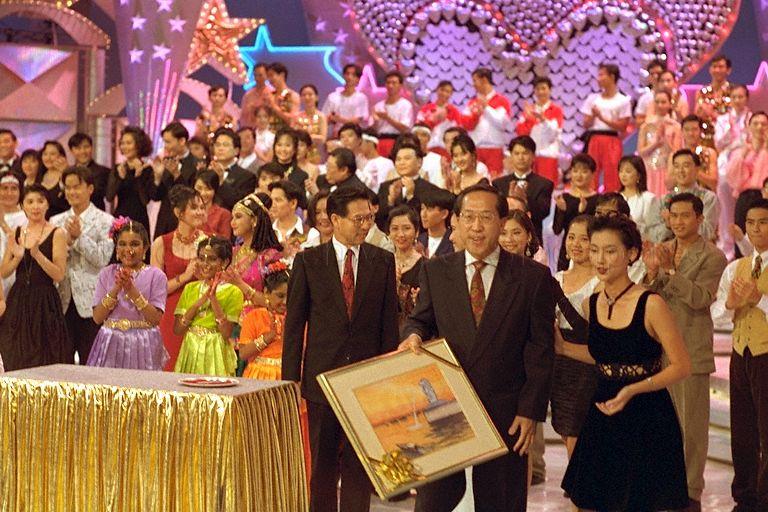 A painting of the Singapore River and the Merlion by a member of the Mouth and Foot Painting Artists, Tan Kok Leong, autographed by President Ong Teng Cheong (shown from the side) was sold for $10,000 to United Overseas Bank during the President's Star Charity show by Television Corporation of Singapore (TCS) artistes held in the TCS theatre
