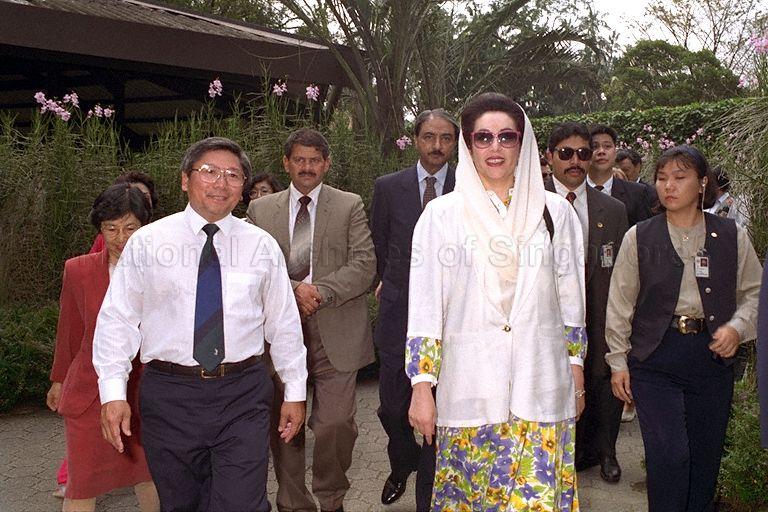 Pakistani Prime Minister Benazir Bhutto, who is in Singapore for a three-day official visit, arriving at Singapore Botanic Gardens for a tour of the Orchid Enclosure. On the left are Executive Director of National Parks Board Dr Tan Wee Kiat and Minister of State for Health and Education Dr Aline Wong (behind him, partially hidden).