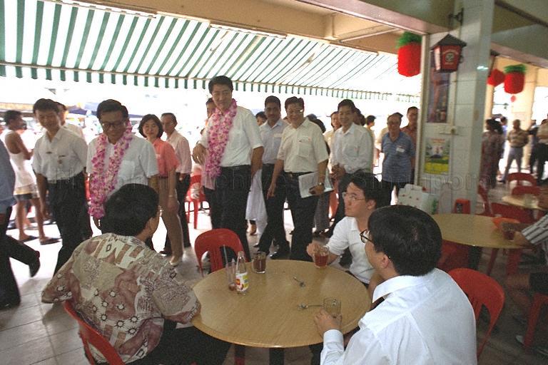 Acting Minister for the Environment and Senior Minister of State for Defence Rear Admiral Teo Chee Hean passing by a coffee shop during community visit to Bukit Panjang. He is accompanied by Senior Parliamentary Secretary, Labour and Member of Parliament for Sembawang Group Representation Constituency Lee Yiok Seng