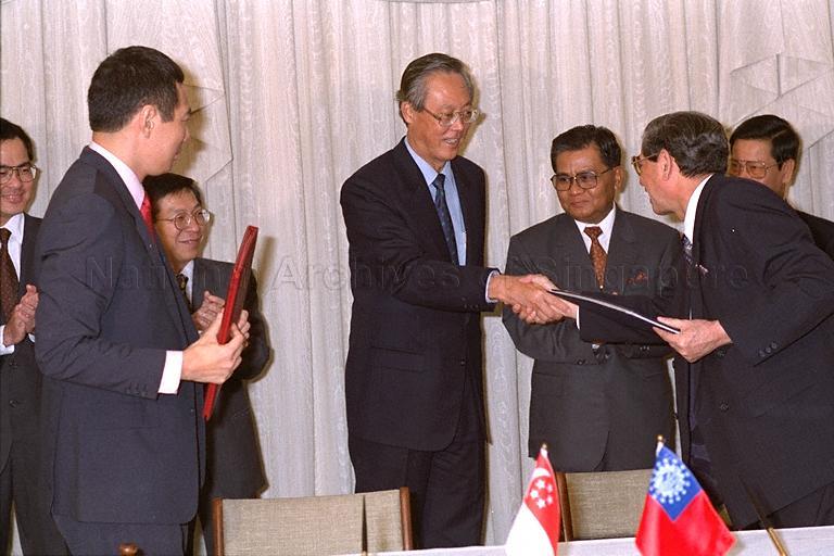 Prime Minister Goh Chok Tong and Myanmar's National Planning and Economic Development Minister Brigadier-General David Abel exchanging a handshake after signing ceremony of bilateral economic agreement between Myanmar and Singapore at Istana Villa. Among those looking on are Chairman of the State Law and Order Restoration Council and Prime Minister of the Union of Myanmar Senior General Than Shwe and Deputy Prime Minister Lee Hsien Loong
