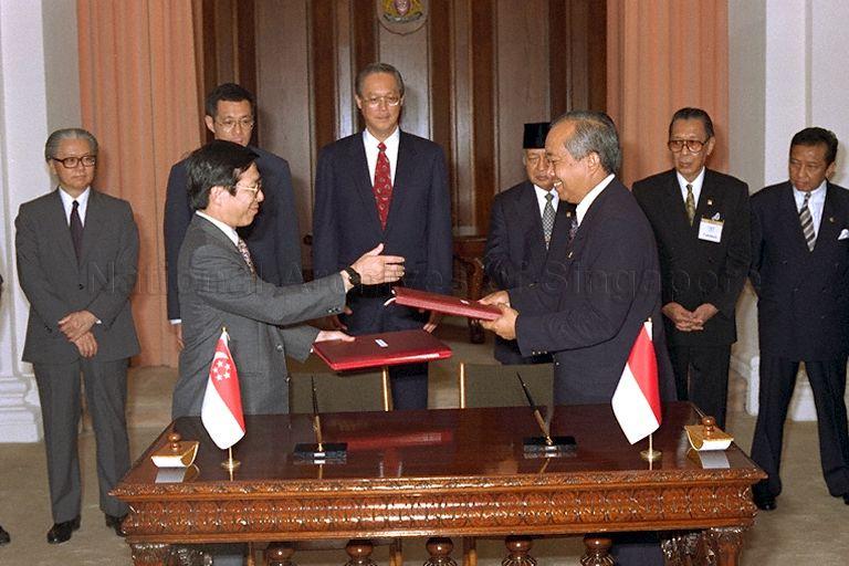 Indonesian Transport Minister Haryanto Dhanutirto and Minister for Communications Mah Bow Tan exchanging the signed civil aviation pact between Indonesia and Singapore during signing ceremony at Istana. Among those present at the ceremony are Indonesian President Soeharto, Prime Minister Goh Chok Tong, Deputy Prime Minister Brigadier-General Lee Hsien Loong and Deputy Prime Minister and Minister for Defence Dr Tony Tan Keng Yam.