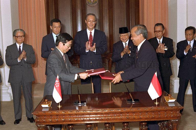 Indonesian Transport Minister Haryanto Dhanutirto and Minister for Communications Mah Bow Tan exchanging the signed civil aviation pact between Indonesia and Singapore during signing ceremony at Istana. Among those present at the ceremony are Indonesian President Soeharto, Prime Minister Goh Chok Tong, Deputy Prime Minister Brigadier-General Lee Hsien Loong and Deputy Prime Minister and Minister for Defence Dr Tony Tan Keng Yam.