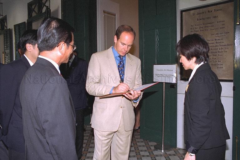Visit by Crown Prince Albert of Monaco, 19 - 21 June 1996 - Prince Albert signing guest book at Singapore Art Museum, with Chief Executive Officer of National Heritage Board Lim Siam Kim (left) looking on