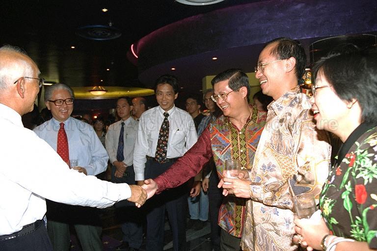 Founder of Golden Harvest Raymond Chow of Hong Kong (back to camera) shaking hands with Associate Professor Wee Chow Hou at the reception during launch of Speak Mandarin Campaign at Golden Village Marina, Marina Leisureplex. Looking on are (from left) Deputy Prime Minister and Minister for Defence Dr Tony Tan Keng Yam, Chairman of Speak Mandarin Campaign Ho Kwon Ping, Minister for Information and the Arts and Minister for Health Brigadier-General George Yeo Yong-Boon and his wife.