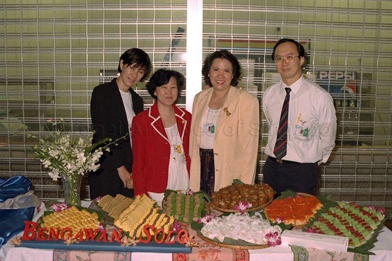 Group photograph of founder and managing director of Bengawan Solo (a bakery chain) Ms Anastasia Tjendri-Liew (second from right) and staff taken at table serving Bengawan Solo food items during World Trade Organisation Ministerial Conference