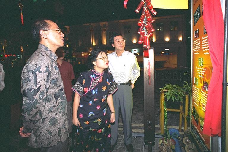 Minister for Information and the Arts and Second Minister for Trade and Industry Brigadier-General George Yeo Yong-Boon and wife, Mrs Jennifer Yeo, viewing exhibits on display panel at Azizah's Restaurant, Albert Court, where the Minister is hosting a farewell dinner for outgoing Parliamentary Secretary to Ministry of Information and the Arts (MITA) Mohamad Maidin Packer Mohd. On the right is MITA Deputy Secretary Tan Tee How.