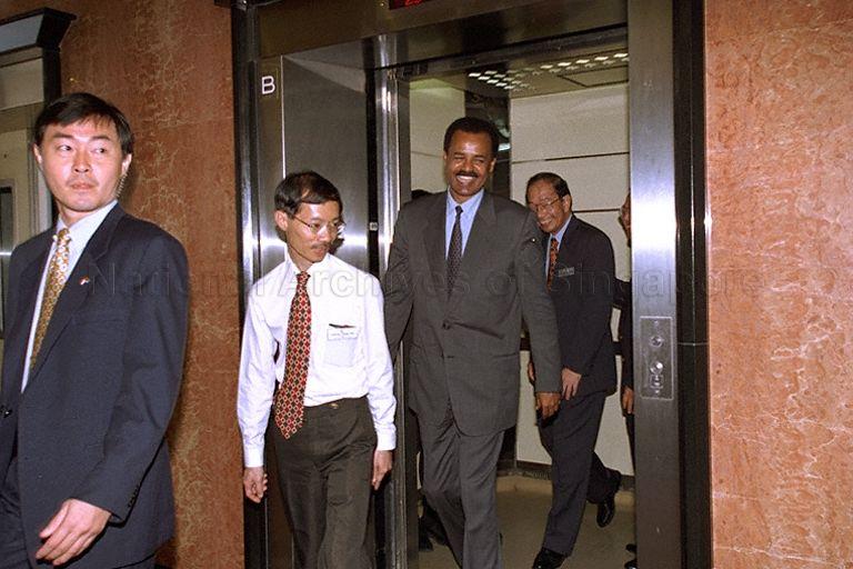 President Isaias Afwerki of Eritrea getting out of the lift at Housing and Development Board (HDB) Toa Payoh branch office at block 81, Lorong 4, where he is shown the panoramic view of HDB estates from the 25th storey. Behind him is HDB Chief Executive Officer Tan Guong Ching.