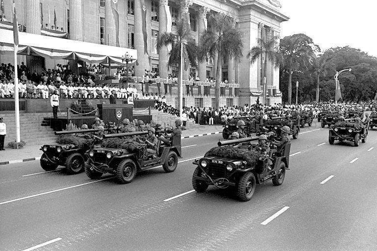 National Day Parade 1969 at the Padang -- View of Singapore Armed Forces (SAF) jeeps mounted with 106mm recoilless rifles moving past City Hall