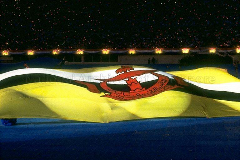 National Day Parade 1997 at National Stadium -- Giant flag of Brunei Darrusalam displayed during performance by SAF Red Lions parachuting team