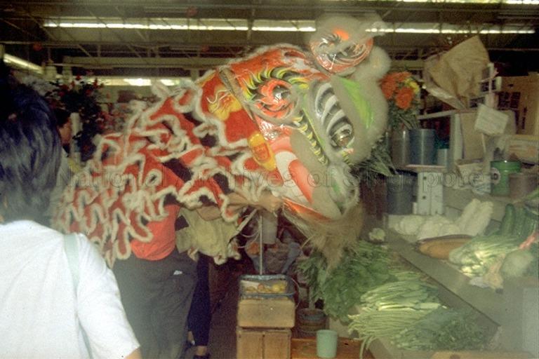 Lion dance performance at vegetable stall in wet market to usher in good luck and fortune for the stall in the new year