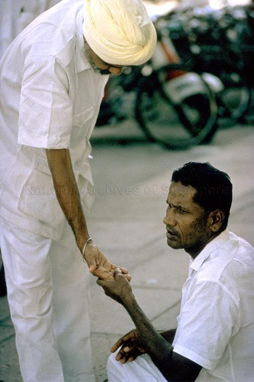A fortune teller (right) reading a palm in Penang
