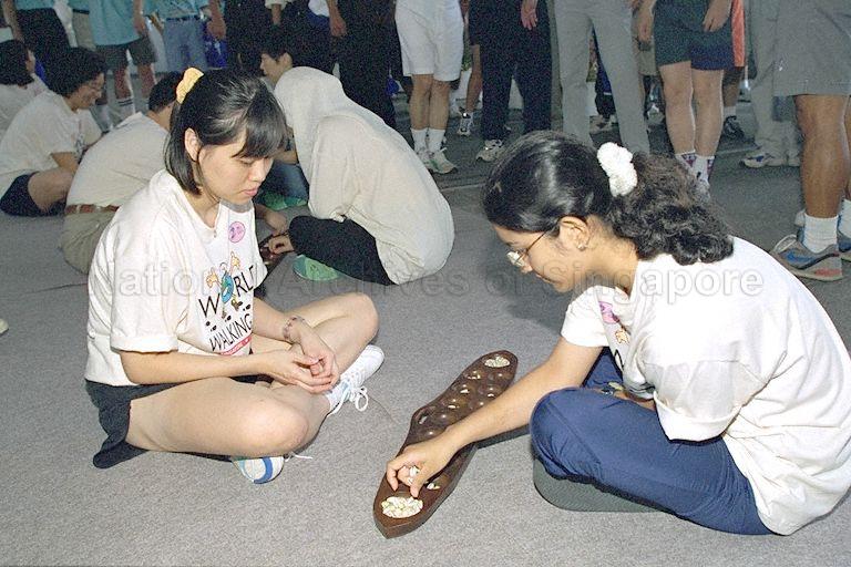 Two girls playing congkak at the National Stadium during the World Walking Day cum launch of Singapore Sports Council’s Employee Fitness Programme