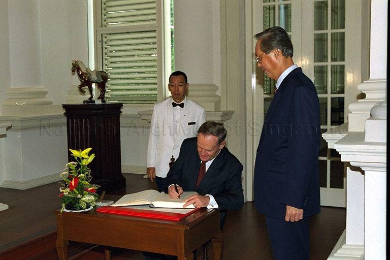 Canadian Prime Minister Jean Chretien signing guest book when he calls on his Singaporean counterpart Goh Chok Tong at Istana lounge